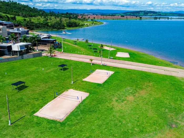 Quadras de areia em gramado de frente para a represa