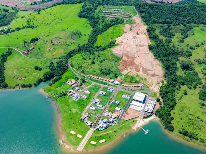 Vista aérea do condomínio na ponta da península, com a fase II em obra no relevo atrás